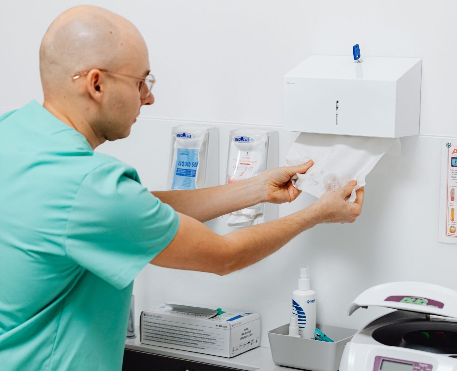 A dentist in a clinic preparing materials with medical instruments visible, promoting hygiene.