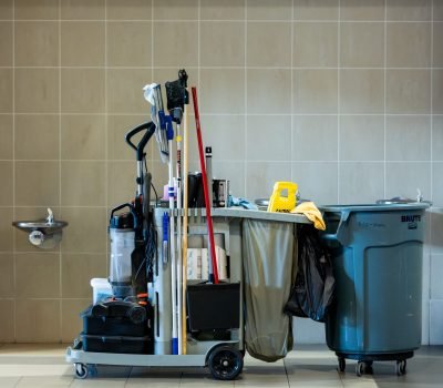 A comprehensive collection of professional cleaning tools on a cart in an indoor environment.